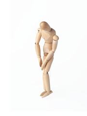 A Wooden dummy with hands down, conveying sadness. A Poseable figure and Articulated mannequin capture a moment of despair, perfect for artists and creating expressive, emotional sketches.