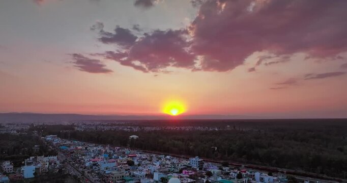 Aerial shot of an Indian city during sunset. Bird eye view of Rishikesh Highway in Rajaji national park, Uttarakhand. Beautiful urban India. Pan shot at Golden hour