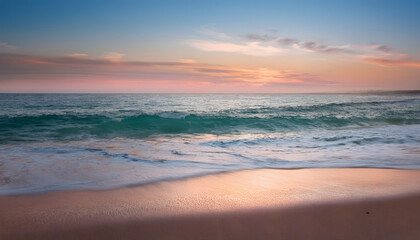 Fototapeta premium Serene beach scene at sunset with gentle waves and a colorful sky reflecting on the water