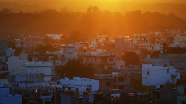 An aerial view of the picturesque city of Dehradun in Uttarakhand, India, captured during a breathtaking sunset. The cinematic shot showcases the city's blend of urban charm and natural beauty.