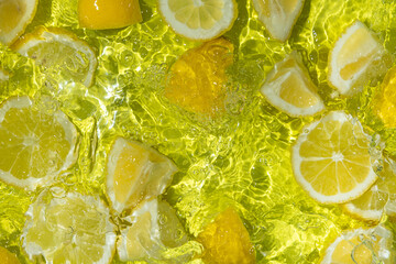 Vibrant yellow lemon pieces floating in motion water
