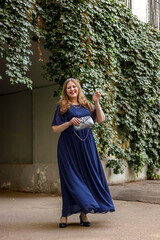 Woman in a long blue dress in the garden.