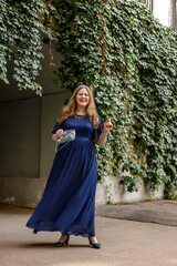 Woman in a long blue dress in the garden.