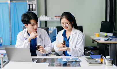 Fototapeta premium Doctors in lab coats discuss medication in a clinical setting, showcasing teamwork and collaboration