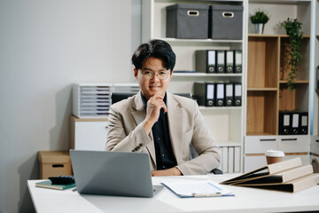 Young business man working at office with laptop, tablet and taking notes on the paper..