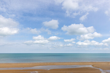 Peaceful seascape with a sandy shoreline, calm ocean waters and sky