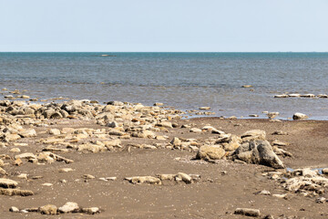 A serene coastal scene featuring a rocky shoreline of Caspian sea