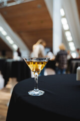 A classic martini glass is elegantly perched upon a luxurious black table cloth, showcasing its fine craftsmanship and beauty, ready to hold a delightful cocktail or beverage of choice