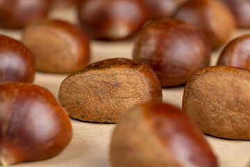 chestnut fruits for frying or baking , preparation by cutting the shells of edible chestnut nuts for baking, close up, side view