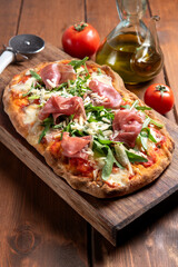 Pinsa romana con prosciutto crudo, parmigiano e rucola, cibo italiano 