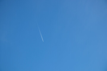 Jet plane aircraft with contrails cruising in the clear sky
