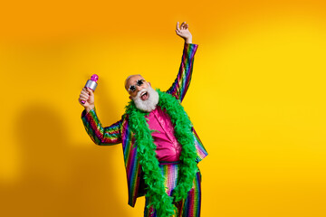 Fototapeta premium Photo of positive old showman enjoy party microphone wear striped suit boa sunglass suit isolated yellow color background