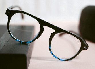 Stylish round eyeglasses with a thick black frame featuring a unique tortoiseshell-like accent...