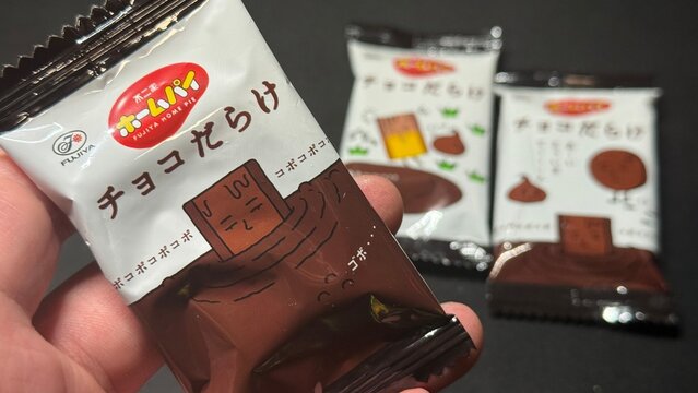 不二家ホームパイ「チョコだらけ」個包装のスナック菓子を手に持った写真｜人気のチョコレート菓子