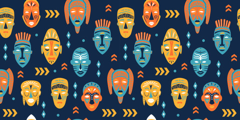 Seamless pattern of ritual masks of African ethnic tribes of various shapes on blue background.