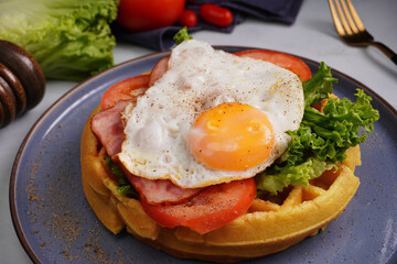 Fried Egg and Pork Waffles Food in a black plate on a wooden table