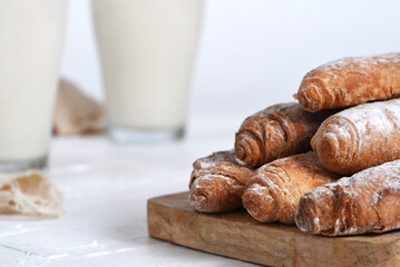 Fartons on a wooden board, accompanied by tigernut horchata served in glass cups. Ideal for illustrating Valencian gastronomy and traditional cuisine.