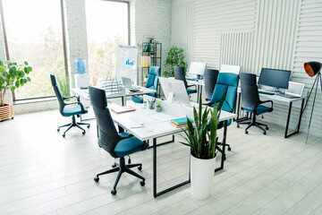 Modern coworking space with stylish office interior featuring desks, chairs, and natural lighting...