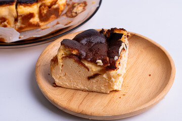 basque burnt cheesecake on wood plate on white background
