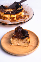 basque burnt cheesecake on wood plate on white background