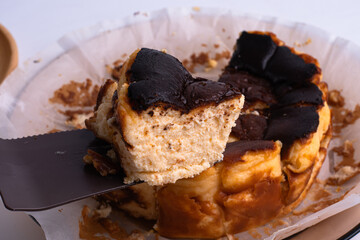 basque burnt cheesecake on wood plate on white background