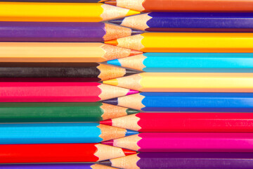 A vibrant stack of colored pencils in various hues, arranged in a grid pattern against a white background. Perfect for art supplies, creativity, and education themes.