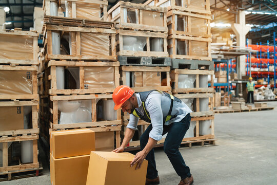caucasian warehouse worker got accident from work at workplace. misadventure got storage staff hurt and need support. asian friend help support caucasian injured employee from carrying heavy crate