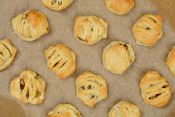 Puff pastry bites filled with mushrooms, arranged on baking paper, shot from above