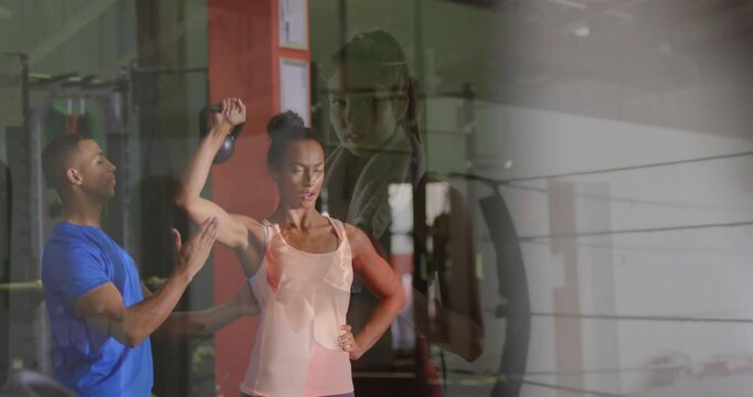 In boxing ring, trainer assisting woman with arm exercise, focusing on technique