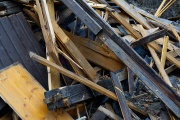 A chaotic pile of broken wooden planks and debris fills the frame, suggesting demolition or cleanup...