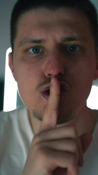 El hombre hace un gesto de silencio con las manos y los labios.
El hombre exige silencio.
Silencio en la habitaci&oacute;n. Nadie oye.