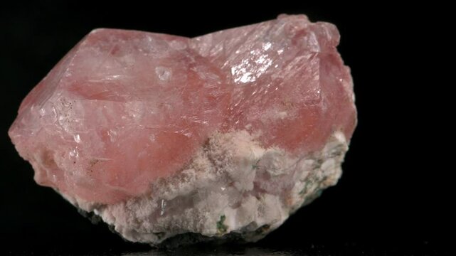 Pink Apophylite crystals on a rock matrix rotating slowly against a black background
