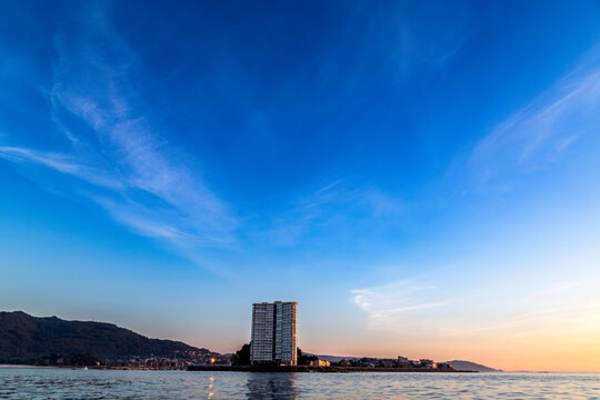Apartment tower on Toralla Island, seen from the sea at sunset. Rias Baixas, Galicia, Spain.