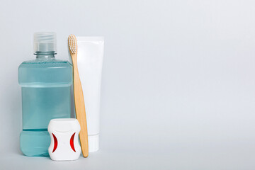 Mouthwash and other oral hygiene products on colored table top view with copy space. Flat lay. Dental hygiene. Oral care products and space for text on light background. concept
