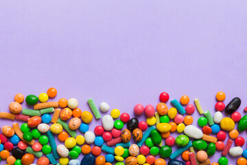 Mixed collection of colorful candy, on colored background. Flat lay, top view. frame of colorful chocolate coated candy