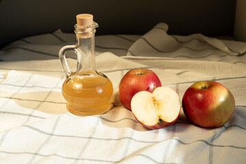 Apple cider vinegar in a jar and apples on the table