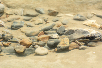 Texture de cailloux sous l'eau et au milieu du sable