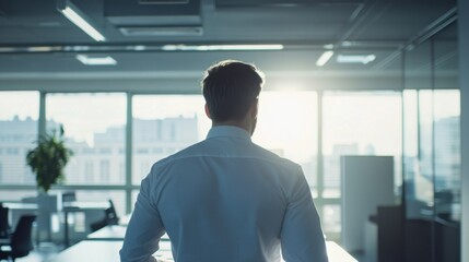 Fototapeta premium A businessman gazes out the office window. Success, strategy, and leadership are key. The future is bright with potential growth.
