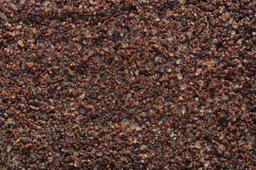 Close up of coarse ground coffee beans texture with rich brown color.