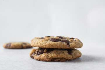 Large chocolate chip cookies on a white countertop, top view of homemade chocolate chip cookies on a white background