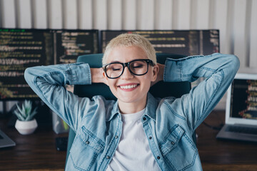 Young professional programmer woman smiling in a casual work environment surrounded by computer...