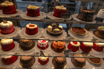 Variety of Colorful Cakes Displayed in Bakery Case During Afternoon