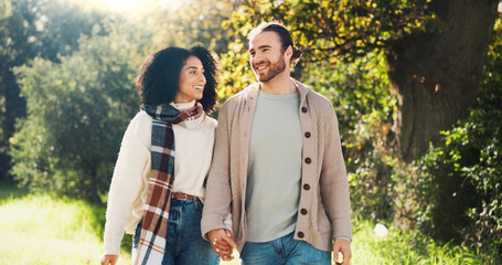 Outdoor, holding hands and couple on walk, nature and people with smile on date, romance and break. Park, man and woman in relationship, love and happy for interracial marriage, travel or together