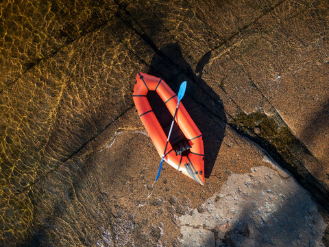 Red packraft on the granite coast top view