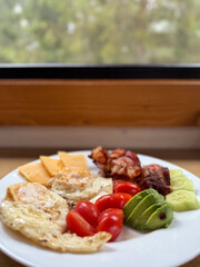 Delicious and Healthy Breakfast Spread Featuring Eggs, Crispy Bacon, Fresh Veggies, and Cheese