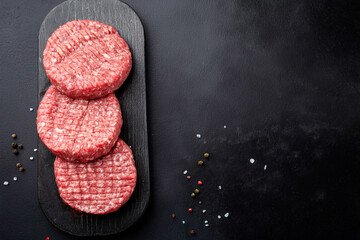 Grilled beef patties on black background. Top view.