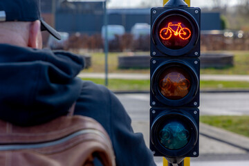 Selective focus of traffic light box for bicycle with red light on at intersection in public to...