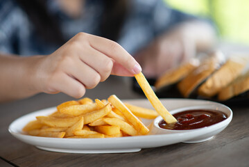 A young girl is happily eating snacks in a cafe.
