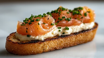 This appetizing image features a beautifully plated bruschetta topped with smoked salmon, creamy spread, and fresh chives, showcasing a delicious appetizer or snack.