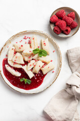 Lazy dumplings, vareniki with raspberry jam decorated with raspberry and mint leaves. Boiled cottage cheese homemade gnocchi.